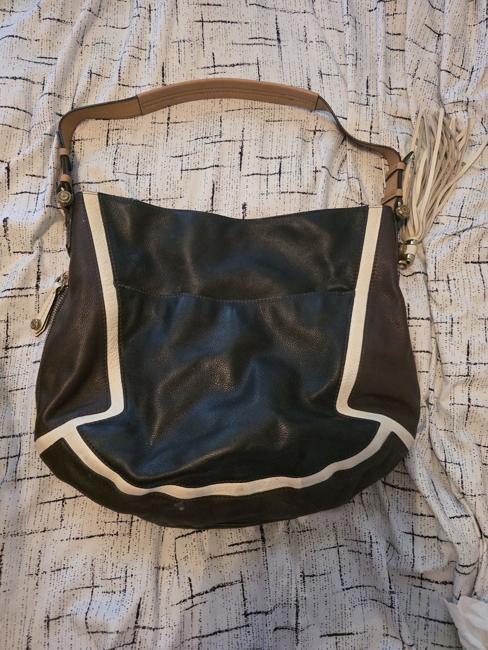 black and tan orYANY Sydney pebbled leather hobo bag featuring brass hardware